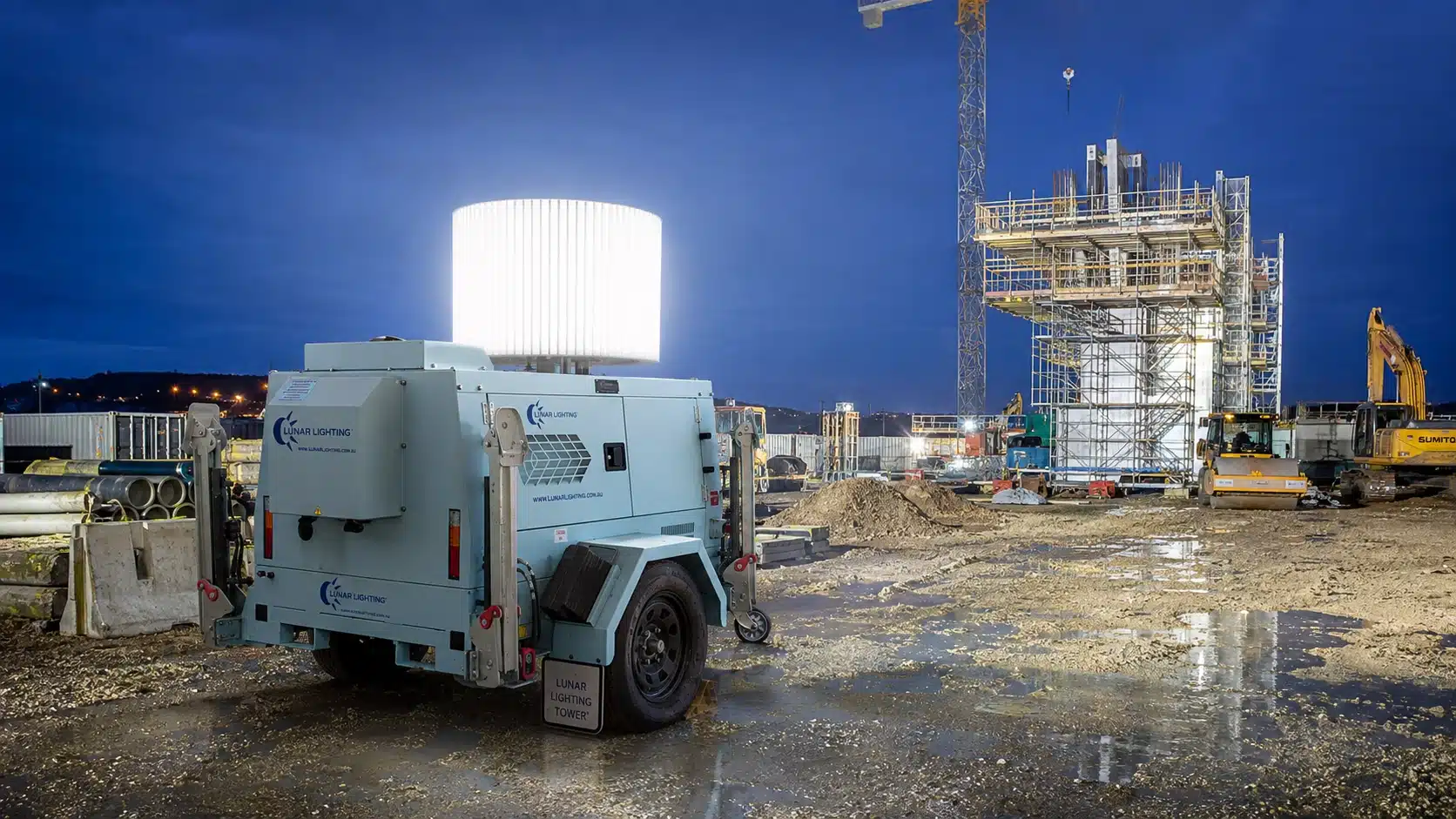 Lunar towable light tower on a muddy civil construction site at night, lighting the whole area